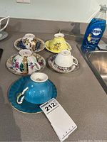 Full set of six teacups and saucers displayed upside down showing exterior design