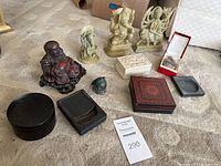 Overview of all figurines, ink stones, carved boxes, and bell in the lot