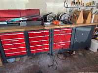 Overall view of assorted tools displayed on red tool cabinet