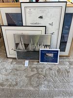 Photo showing five framed nautical art prints grouped together, and one book by Steve Mayo in front