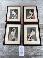 Four framed Yakusha-e prints arranged on carpet floor, showing full lot of four prints with various actors.