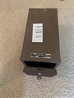 Angled top view of the safety box with drawer slightly opened and key inserted in lock.