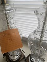 Close-up photo of one crystal table lamp showing geometric cut design on clear glass and metal base