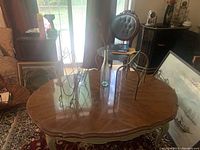 Photo of wooden living room table showing the dark brown polished top and curved pale painted legs and edges.