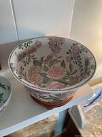 Image of large ceramic bowl with floral decoration on wooden stand