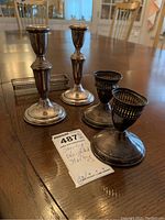 View of all items: 2 taller candle holders, 2 shorter pierced candle holders, and cracker caddy on wood table