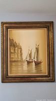 Full view of framed wall art depicting sailboats near a building, signed by Marini.