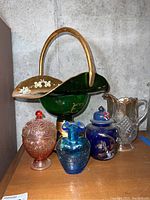 Photo showing the complete set of six colored glassware items on wooden surface