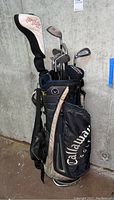Overall view of the left handed golf clubs stored in a Callaway branded golf bag with visible F15 head cover
