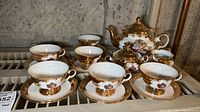 Full set displayed showing teapot, creamer, sugar bowl, 6 cups and 6 saucers on a rack.
