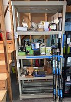 Front view of first plastic shelving unit with four shelves containing small boxes and items (not included).