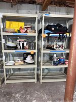 Two beige plastic shelving units side by side in a basement, containing various items (not included) for scale and reference.