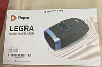 Photo of the product box front side showing product name and image of hand massager.