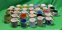 Front view of 40 vintage multi-colored coffee mugs arranged in rows with various designs including florals, fruits, and text phrases.