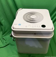 Front angle view of white Midea cube dehumidifier showing overall shape and drainage hose.