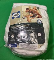 Photo of the packaged Sealy Luxury Knit King size fitted mattress protector with brand logo, product name, and features visible.