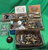 Top view of the vintage hardware lot showing various boxes filled with plumbing valves, electrical components, screws, spools of wire, and a vintage oil can.