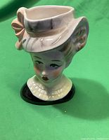 Front angled view of the lady head vase showing the face details, hat, and glossy finish.