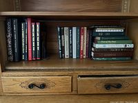 Shelf with 20 hardcover and paperback books on business, literature, and self-help topics.
