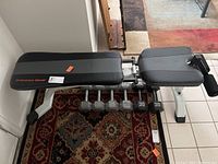 Fitness Gear padded weight bench and six hex dumbbells arranged on the floor.