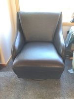 Front view of one black swivel armchair showing seat cushion and backrest.