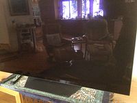 Front view of LG 55″ OLED flatscreen on stand showing screen surface and overall condition