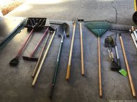 Row of long-handled garden tools laid flat