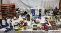 Wide view of assorted hardware and household repair items including caulking guns, tapes, sealants, hooks, and organizing cabinet