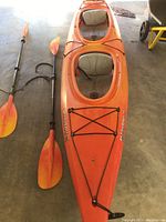 Overhead view of entire 2-seat kayak with both paddles laid alongside