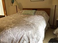 Full front view of queen bed with bedding