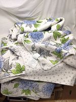 Quilted bedspread with floral and polka dot reversible patterns folded showing fabric texture and colors.