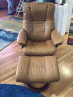 Front view of mocha leather recliner chair and ottoman on wood floor