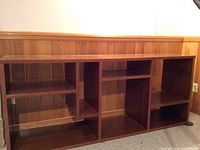 Front view of the red mahogany veneer wooden shelf showing multiple open compartments of various sizes.