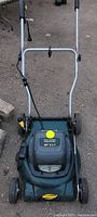 Front view of green and black Hardworks electric lawn mower showing the handle, wheels, and 20 inch 3-in-1 label on the top cover.