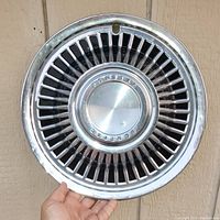 Front view of one vintage Pontiac 14-inch metal hubcap showing detailed multi-spoke design and center PONTIAC embossing.