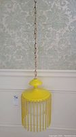 Full view of the yellow hanging lamp with chain showing overall design and structure