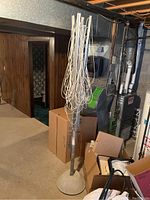 Full view of the clothes dryer standing upright in a basement, surrounded by boxes and furnace equipment.