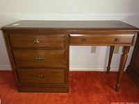 Front view of the Vilas Canada wooden desk showing all four drawers and tapered legs.