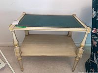 Full view of the wood side table showing rectangular shape, green inset top, lower shelf, and turned carved legs.