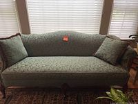 Front view of green couch showing upholstery, cushions, and shape