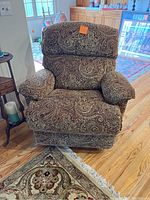 Front view of the Lazy Boy recliner chair showcasing its paisley patterned upholstery, cushioned armrests and backrest.