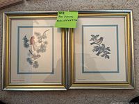 Two framed bird prints side by side. Each has birds perched on pine branches with muted natural tones, signed but artist not fully visible. Frames are gold with silver border.