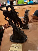 Side view showing mountain man and horse descending rock formation on marble base