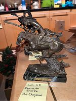 Front-left angle of bronze sculpture showing warrior, horse and marble base