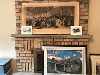 Full view showing large antique British railway print mounted above fireplace, with two black and white photo prints on mantle and large framed limited edition CP Rail print below