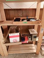 Overview of lot items on wooden shelving, showing top and bottom trays