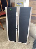 Front view of ramp folded in half showing black traction surface and aluminum frame.