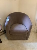 Front view of the brown Natuzzi Editions velour swivel accent chair showing barrel shape and cushion seat.