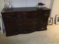 Front view of mahogany buffet showing serpentine front, three central drawers and side cabinets