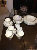 Photo showing the full set of plates, cups, cream pitcher, and sugar bowl on a table.
